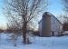 an old white barn and silo